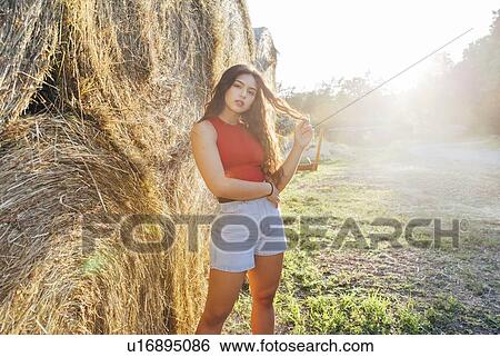 Woman standing by round bales of hay, Wilhelminenberg, Vienna, Austria View Large Photo Image Stock Photograph - Woman standing by round bales of hay, Wilhelminenberg, Vienna, Austria. Fotosearch