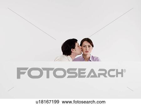Woman unimpressed with male colleague kissnig her View Large Photo Image Stock Photo - Woman unimpressed with male colleague kissnig her. Fotosearch