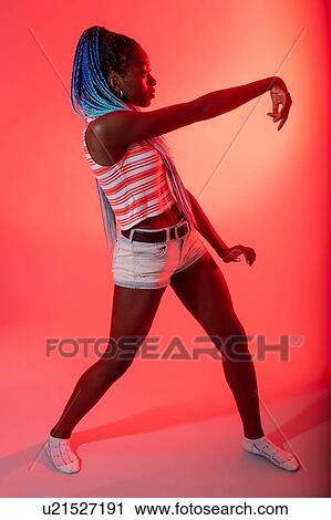 Stock Image - Woman with arm reaching out against red background. Fotosearch