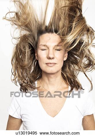 Woman with flying hair closing eyes, white background View Large Photo Image Stock Photography - Woman with flying hair closing eyes, white background. Fotosearch
