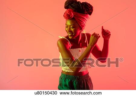 Woman with headscarf dancing against peach background View Large Photo Image Stock Image - Woman with headscarf dancing against peach background. Fotosearch