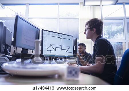 Stock Image - Worker looking at CAD design of product in electronics assembly factory. Fotosearch
