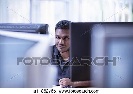 Stock Photography - Worker looking at screen in office in electronics assembly factory. Fotosearch