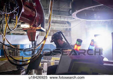 Stock Photography - Worker making sand mould for pouring molten steel into steelworks. Fotosearch