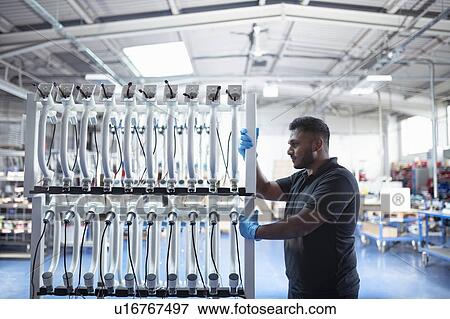 Worker with electronic parts on racks in electronics assembly factory View Large Photo Image Stock Photo - Worker with electronic parts on racks in electronics assembly factory. Fotosearch