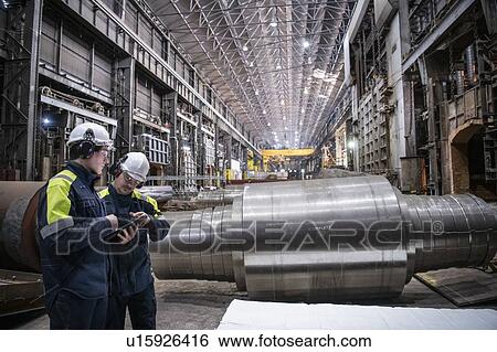 Workers inspecting large steel roller in forge of steelworks View Large Photo Image Stock Photograph - Workers inspecting large steel roller in forge of steelworks. Fotosearch