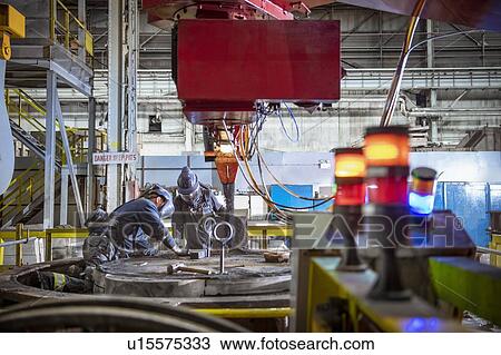 Workers making sand mould for pouring molten steel into steelworks View Large Photo Image Stock Image - Workers making sand mould for pouring molten steel into steelworks. Fotosearch