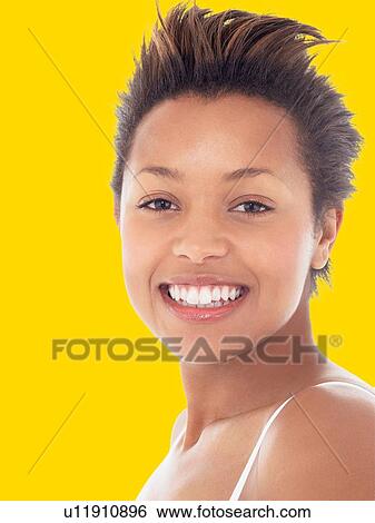 Stock Photograph - Young attractive black woman Smiling against yellow background. Fotosearch