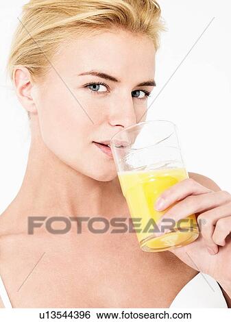 Stock Photograph - Young attractive blonde Woman Drinking Orange Juice. Fotosearch