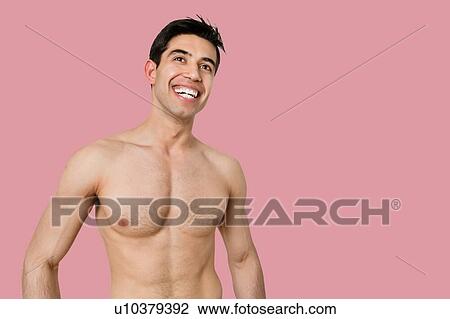 Young bare chested man smiling while looking away over pink background View Large Photo Image Stock Image - Young bare chested man smiling while looking away over pink background. Fotosearch