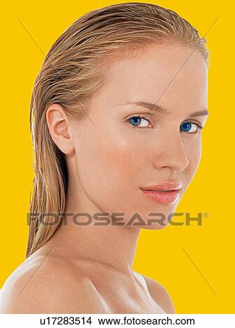 Picture - Young Blond Woman with blue eyes against yellow background. Fotosearch