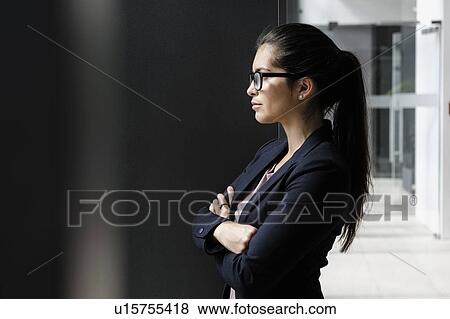 Young businesswoman taking break at corridor of office building View Large Photo Image Stock Photo - Young businesswoman taking break at corridor of office building. Fotosearch