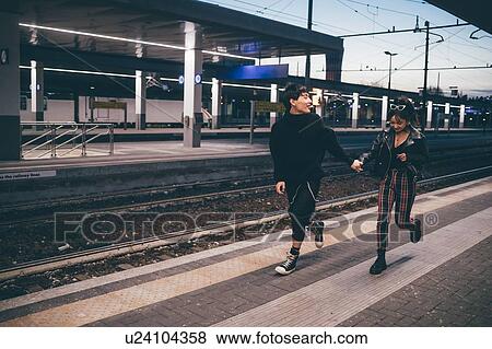 Young couple running on platform in train station, Milan, Italy View Large Photo Image Stock Photo - Young couple running on platform in train station, Milan, Italy. Fotosearch