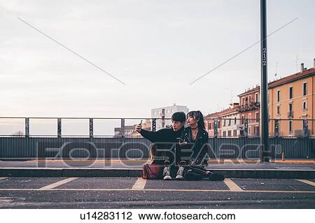 Young couple taking selfie on kerb, Milan, Italy View Large Photo Image Stock Image - Young couple taking selfie on kerb, Milan, Italy. Fotosearch
