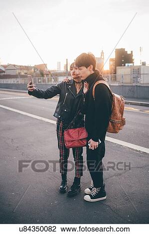 Young couple taking selfie on street, Milan, Italy View Large Photo Image Stock Image - Young couple taking selfie on street, Milan, Italy. Fotosearch
