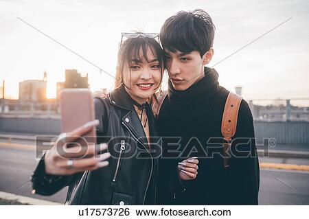 Young couple taking selfie on street, Milan, Italy View Large Photo Image Stock Photograph - Young couple taking selfie on street, Milan, Italy. Fotosearch