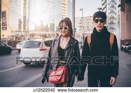 Young couple walking and holding hands on street, Milan, Italy View Large Photo Image Stock Image - Young couple walking and holding hands on street, Milan, Italy. Fotosearch