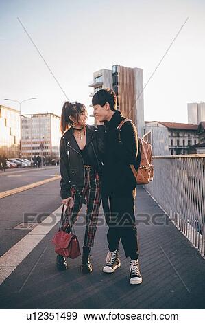 Stock Photo - Young couple walking on street, Milan, Italy. Fotosearch