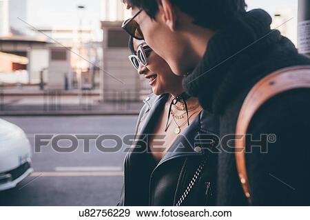 Stock Photo - Young couple walking on street, Milan, Italy. Fotosearch