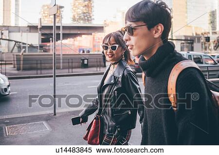 Stock Photography - Young couple walking on street, Milan, Italy. Fotosearch