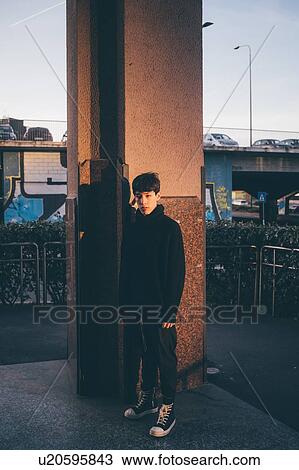Stock Image - Young man, pillar in background, Milan, Italy. Fotosearch