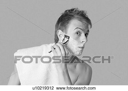 Young man shaving his face in black and white View Large Photo Image Stock Image - Young man shaving his face in black and white. Fotosearch