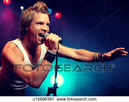Stock Image - Young Man Singing at rock Concert. Fotosearch