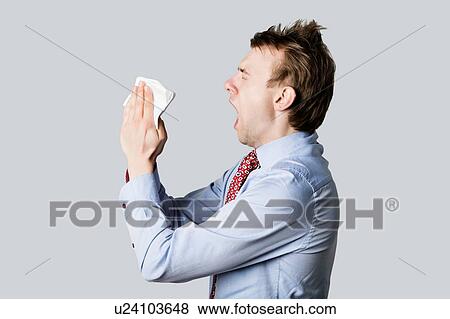 Young man sneezing with open mouth and handkerchief View Large Photo Image Stock Photo - Young man sneezing with open mouth and handkerchief. Fotosearch