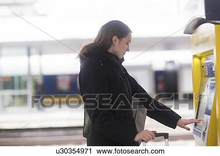 Young woman at ticket machine in train terminal View Large Photo Image Stock Image - Young woman at ticket machine in train terminal. Fotosearch