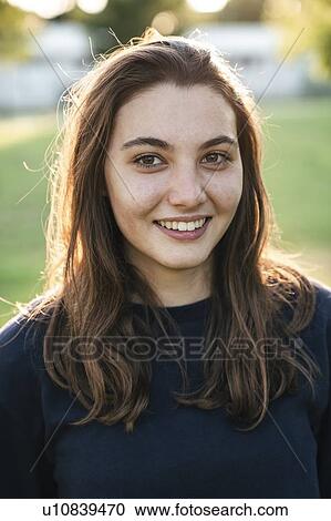Stock Image - Young woman in park. Fotosearch