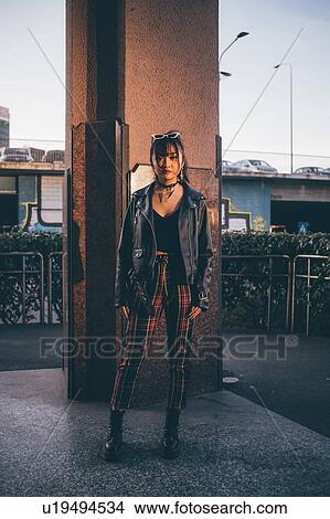 Picture - Young woman, pillar in background, Milan, Italy. Fotosearch