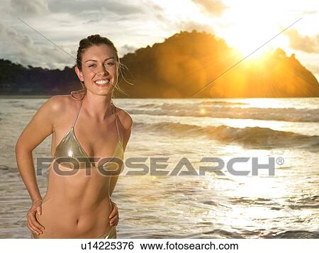 Young Woman Wading in Ocean at Sunset View Large Photo Image Stock Photograph - Young Woman Wading in Ocean at Sunset. Fotosearch