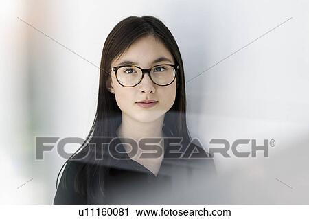Stock Image - Young woman with round eye glasses. Fotosearch