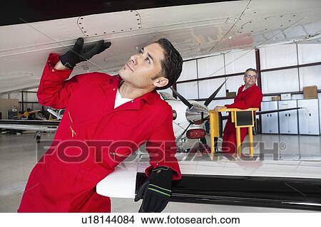 Picture - Aeronautical engineers working in airplane hangar. Fotosearch