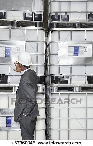 Stock Photograph - African American male engineer inspecting in manufacturing company. Fotosearch