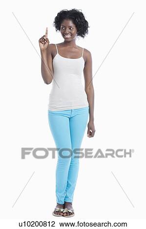 Stock Image - African American young woman pointing her index finger upwards over white background. Fotosearch