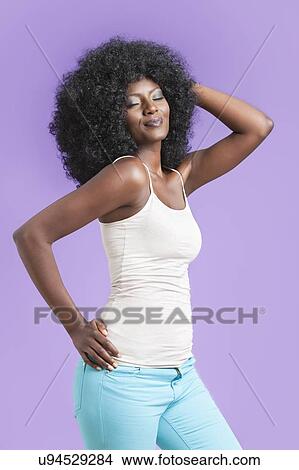 Picture - African American young woman posing over violet background. Fotosearch