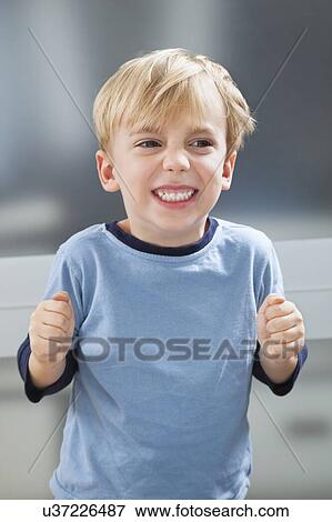 Stock Photo - Angry Caucasian boy in sleepwear clenching his teeth. Fotosearch