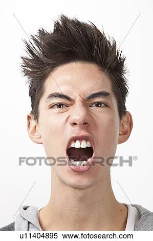 Stock Photography - Angry young man screaming against white background. Fotosearch