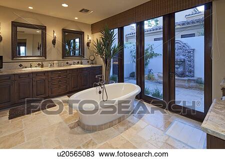 Stock Image - Bathtub in spacious bathroom of luxury villa. Fotosearch