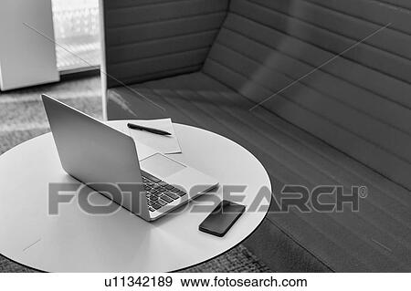Stock Photo - Black and white photo of laptop and smartphone on table in office. Fotosearch