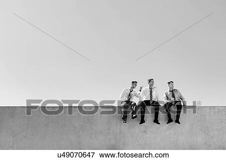 Black and white photo of thoughtful businessmen sitting and relaxing on rooftop View Large Photo Image Stock Photo - Black and white photo of thoughtful businessmen sitting and relaxing on rooftop . Fotosearch