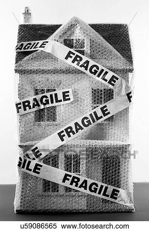 Stock Photography - Black and white photo of toy house wrapped in bubble wrap and fragile sticker concept. Fotosearch