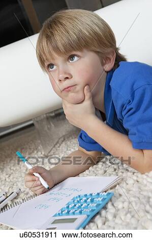 Boy contemplating while doing homework in house View Large Photo Image Stock Image - Boy contemplating while doing homework in house. Fotosearch