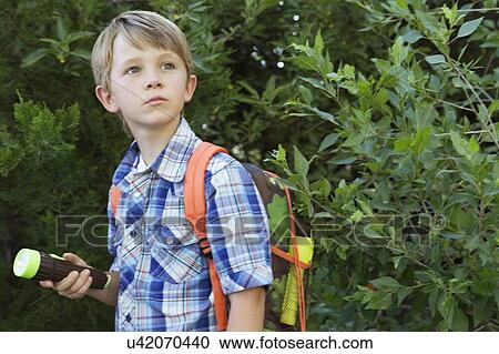 Boy with backpack and torch in front of plants View Large Photo Image Stock Image - Boy with backpack and torch in front of plants. Fotosearch