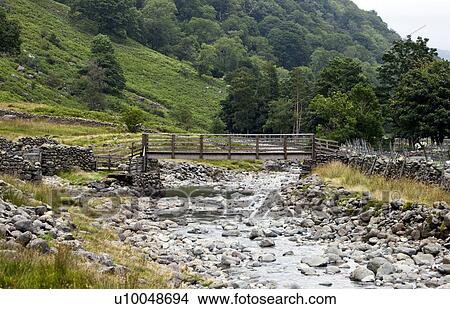 Bridge with slow flowing river in countryside View Large Photo Image Picture - Bridge with slow flowing river in countryside. Fotosearch