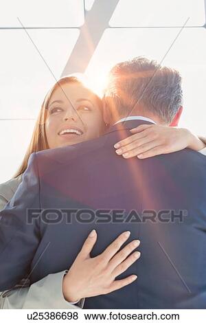 Business couple reuniting and embracing each other in the airport View Large Photo Image Stock Photo - Business couple reuniting and embracing each other in the airport. Fotosearch