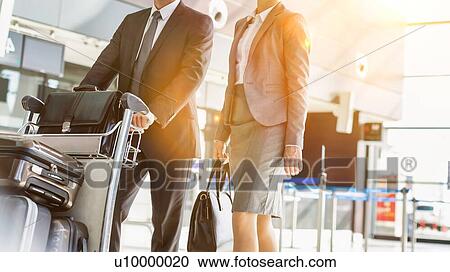 Stock Image - Business people checking their bags in airport. Fotosearch