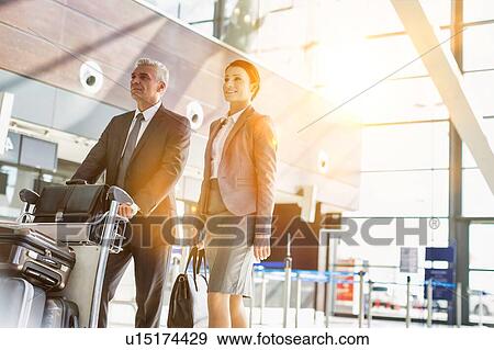 Business people checking their bags in airport View Large Photo Image Stock Photo - Business people checking their bags in airport. Fotosearch