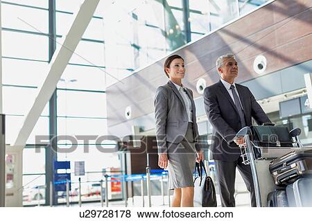 Business people checking their bags in airport View Large Photo Image Stock Photo - Business people checking their bags in airport. Fotosearch